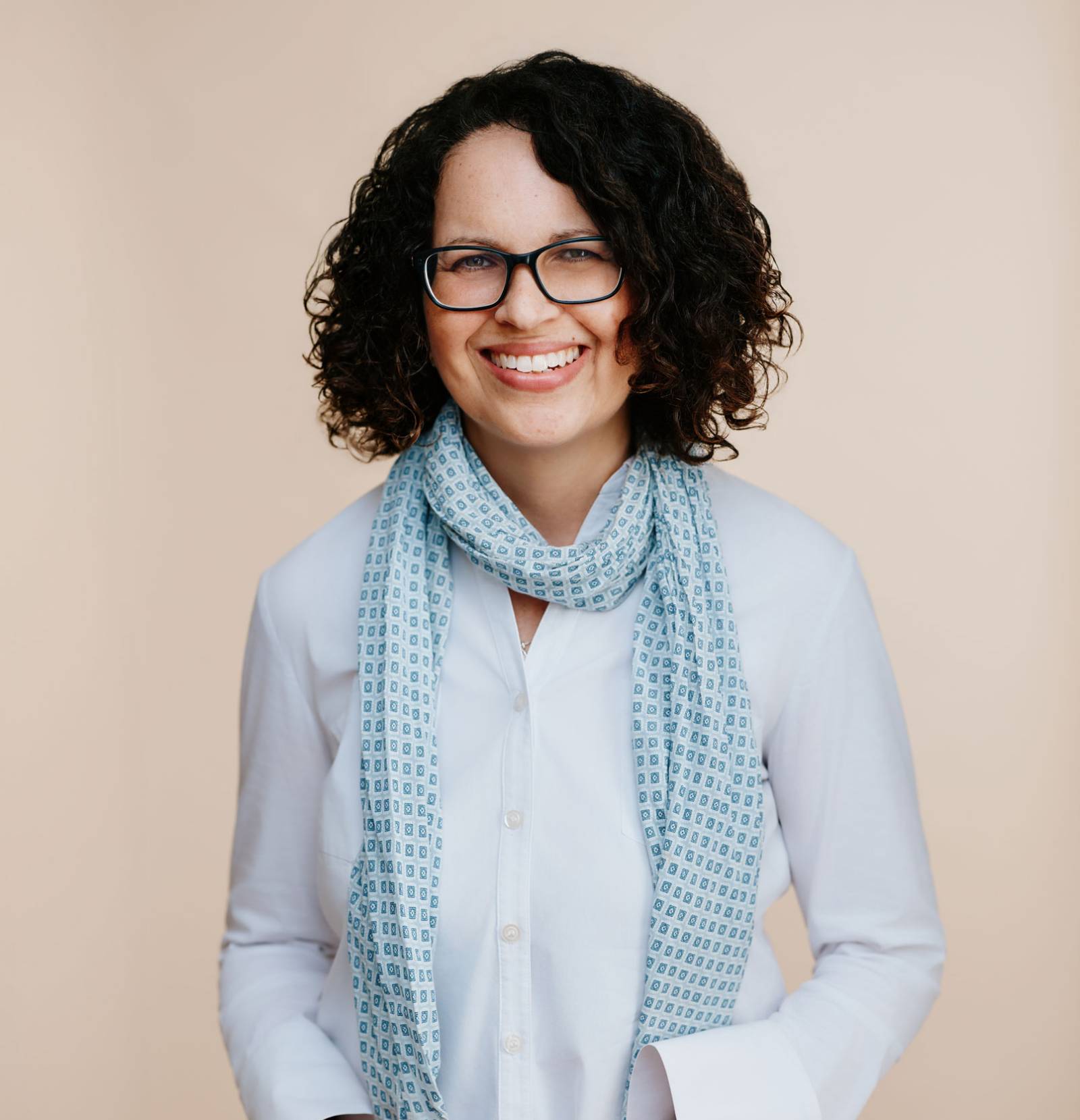 a woman with glasses and a scarf around her neck