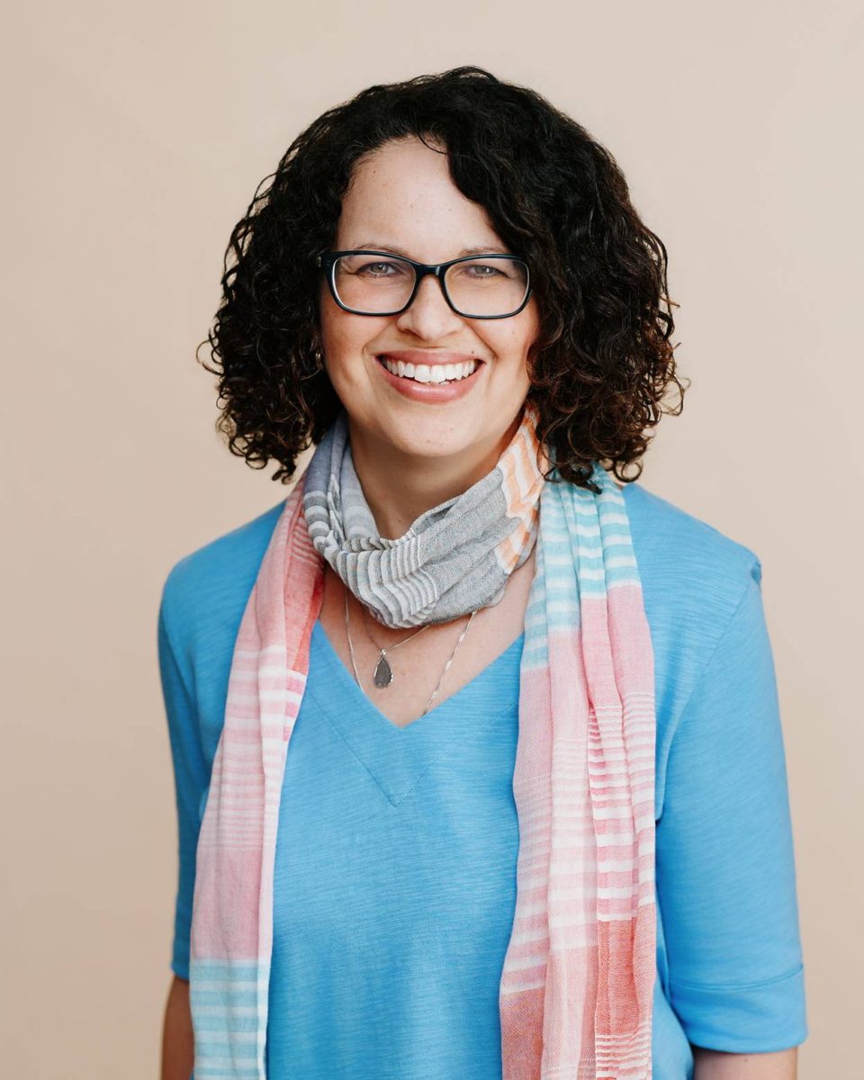 a woman with glasses and a scarf around her neck